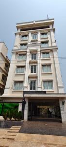a tall white building with stairs in front of it at Hotel Rock Port Inn in Rushikonda