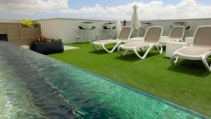 a group of chairs and a swimming pool at URBANSEA Bex in Las Palmas de Gran Canaria