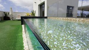 an infinity pool in a house with green grass at URBANSEA Bex in Las Palmas de Gran Canaria