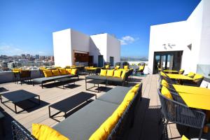 a patio with yellow chairs and tables on a roof at URBANSEA Bex in Las Palmas de Gran Canaria +31 photos