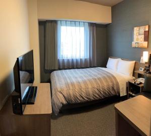 a hotel room with a bed and a window at Hotel Route-Inn Kamisu in Kamisu