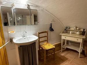 a small bathroom with a sink and a chair at La Catounière - Maison de village avec magnifique vue in Mons +15 photos