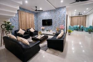 a living room with couches and a tv at Premium Villa Stay Near the Airport Perfect for Families & Business Travelers in Hyderabad