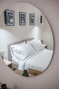a bedroom with a bed with white sheets and a mirror at Aurora apartments Room 1 in Marmari