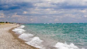 a beach with boats in the water and a cloudy sky at Dimora Patio in Policoro