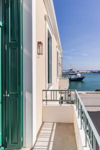 a building with a green door and a boat in the water at Promenade Chios Port Residences in Chios