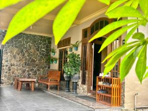 a porch of a house with a bench and a table at Good Feeling Ijen Banyuwangi in Banyuwangi