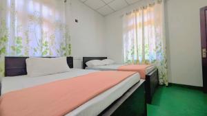 a bedroom with two beds and curtains and green floors at Haputale Hills Holiday Home in Haputale +20 photos