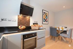 a kitchen with a counter and a table with a bowl of fruit at Fossgate Luxury Duplex City Centre Apartment with Free Parking in York