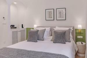 a bedroom with a bed with white sheets and pillows at Promenade Chios Port Residences in Chios