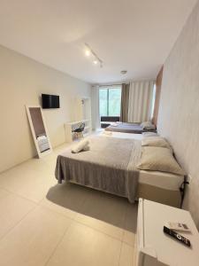 a large bedroom with two beds and a television at Pousada Jardins in São Luís +84 photos