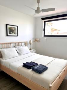 a bedroom with a bed with two towels on it at Hostel do Alto - Fão in Esposende