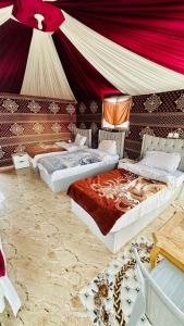 two beds in a room with a tent at Star City Camp wadirum in Wadi Rum