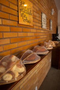 a buffet line with trays of bread and pastries at Pousada Jardins in São Luís