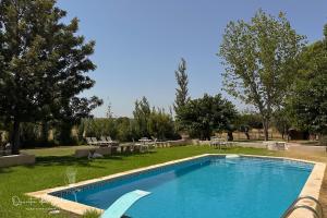 a swimming pool in a yard with tables and chairs at Quinta da Vala - Veranda Suite 1 in Porches
