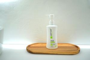 a bottle of mouth wash sitting on a wooden board at Spacious 3BR, 2BT with 5 balconies in Bucharest