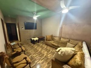 a living room with a couch and a flat screen tv at Alanna temporada in Olímpia