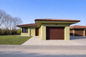 a house with a garage in front of it at Domček pri golfe in Skalica