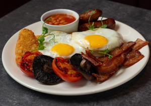 a plate of breakfast food with eggs and mushrooms at Zedwell Underground Hotel Tottenham Court Rd in London