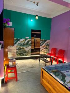 a room with a bed and some red chairs at Zen Garden Homestay in Jorhat +10 photos