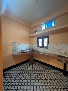 a large kitchen with a counter and a window at Zen Garden Homestay in Jorhat