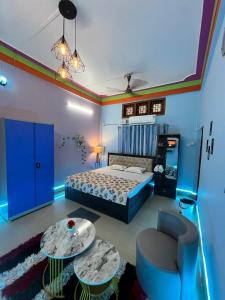 a bedroom with a bed and a chair and a table at Zen Garden Homestay in Jorhat