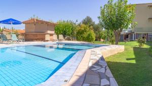 a swimming pool in a yard next to a house at Abelia Abode Apt in Kavros