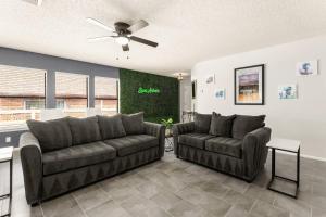 a living room with two couches and a ceiling fan at SeaCasa San Antonio in San Antonio