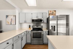 a kitchen with white cabinets and stainless steel appliances at SeaCasa San Antonio in San Antonio