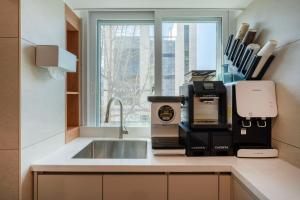 a kitchen counter with a sink and a window at KIMSTEL Jongno in Seoul