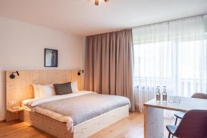 a bedroom with a bed and a desk and a window at stuub jostal in Titisee-Neustadt +19 photos
