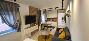 a small living room with a couch and a tv at Apartments Lisinski - FREE parking in Zagreb