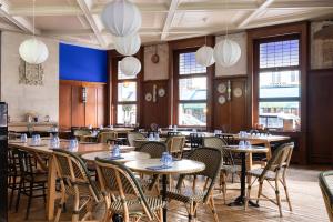 a dining room with tables and chairs and lights at Normandy Le Chantier in Paris