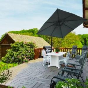 a patio with a table and chairs and an umbrella at La maison de Dourils in Entraygues-sur-Truyère