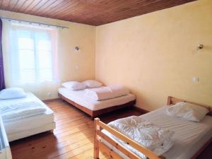 a room with two beds and a window at L'âne à plumes in Coisia