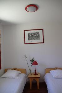 a bedroom with two beds and a table with a lamp at Oly Vacances Les Landes in Cassen +13 photos
