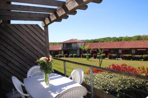 a table and chairs on a balcony with a garden at Oly Vacances Les Landes in Cassen