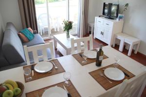 a living room with a table with plates and wine glasses at Oly Vacances Les Landes in Cassen