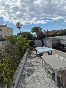 a patio with a table and benches on a roof at Villa Good Vibes in Ifach