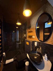 a bathroom with a black sink and a mirror at Große Fewo mit 2 SZ & 2 Bäder mit Parkplatz BoLA 22 in Hamburg