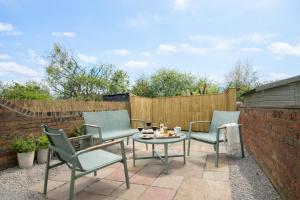 a patio with chairs and a table and a fence at York Boutique House- spacious & stylish with free parking in York