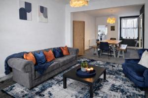 a living room with a couch and a table at York Boutique House- spacious & stylish with free parking in York