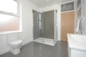 a bathroom with a toilet and a shower and a sink at York Boutique House- spacious & stylish with free parking in York
