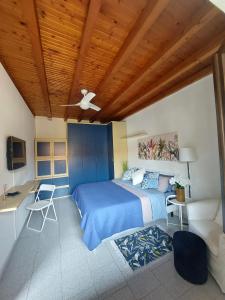 a bedroom with a blue bed and a wooden ceiling at La casetta in Cesano Maderno +1 photo