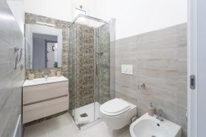 a bathroom with a toilet and a shower and a sink at Via del Mare in Giba