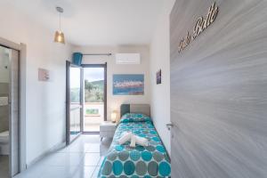 a bedroom with a bed and a door to a bathroom at Via del Mare in Giba +17 photos