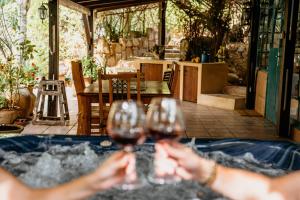 two people holding wine glasses in front of a hot tub at חוות טפת בגלבוע-חוויה של טבע בצפון in Nurit