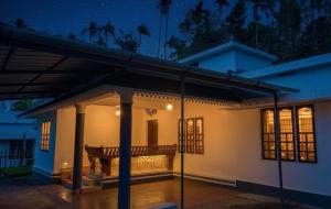 a house with a lit up porch at night at Villa 9 degrees north in Sultan Bathery