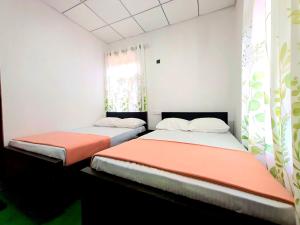 two beds in a room with white walls at Haputale Hills Holiday Home in Haputale