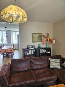 a living room with a brown couch and a table at Les Gîtes d'Argonne in Rarécourt